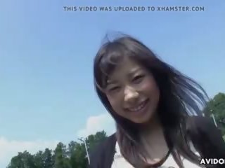 Attractive asiatisk gal sprer seg ben utendørs til fin finger.